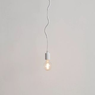 Exposed light bulb on white cord