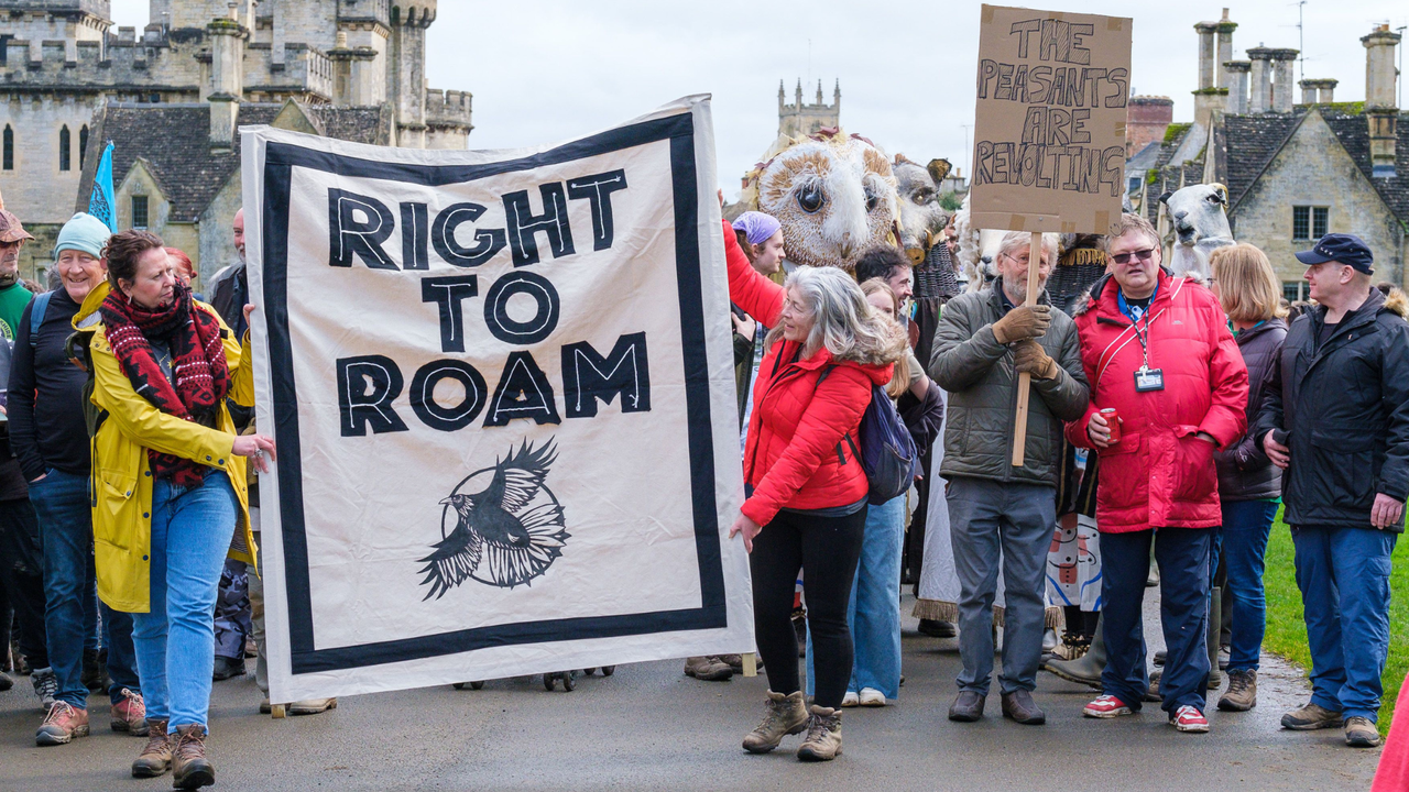 Protesters holding a banner that says &#039;right to roam&#039; walk through Cirencester park