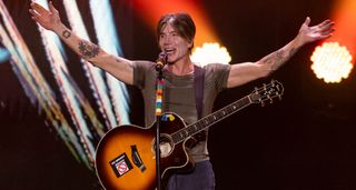 Arms outstretched, John Rzeznik of Goo Goo Dolls works the crowd with an Ibanez acoustic