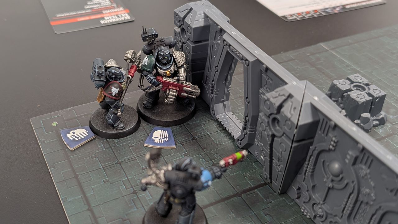 Three Deathwatch models on the Kill Team: Tomb World board, alongside terrain