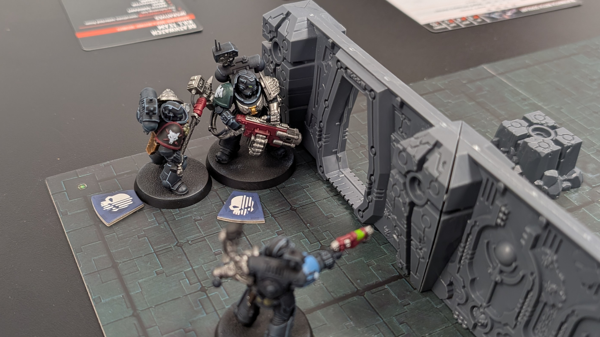 Three Deathwatch models on the Kill Team: Tomb World board, alongside terrain