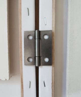 close up of hinges placed on wooden canvas frame