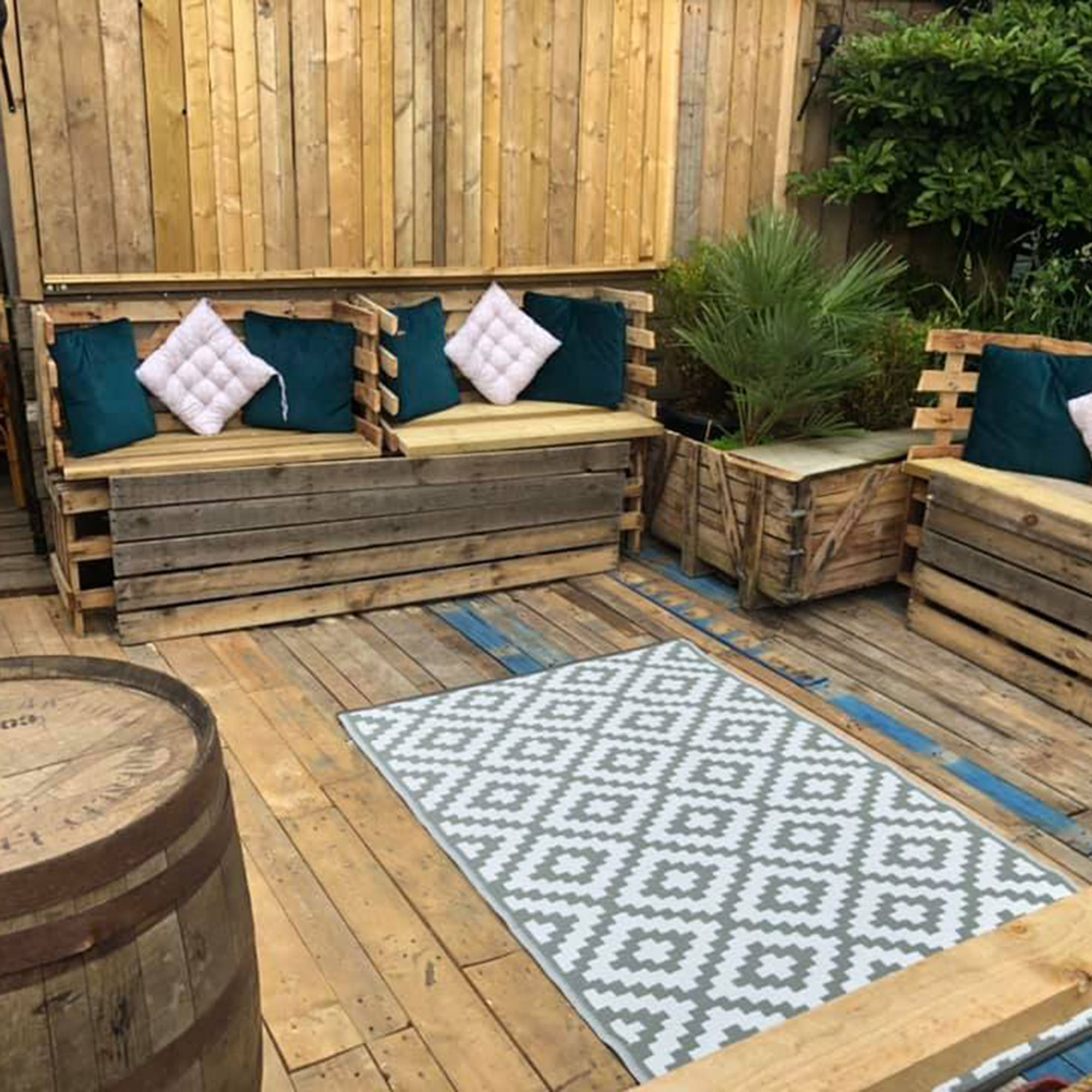 drinking spot with wooden flooring and rug on floor with wooden bench and cushions