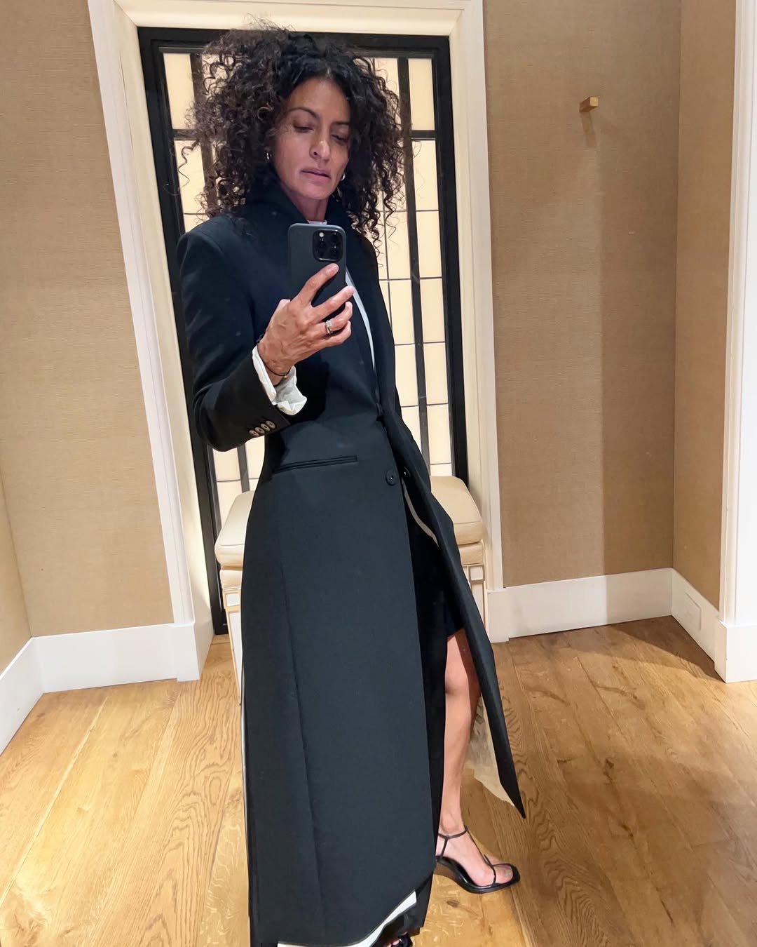 Neelam Ahooja wearing a black tailored coat