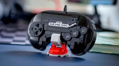 Lego Sega Genesis Controller set on a red stand, sitting on a blue surface