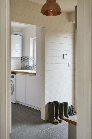 white utility room off hallway with tongue and groove panelling
