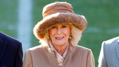 Queen Camilla's cosy camel look seen again. Here she wears the same coat and hat to visit Wrexham Association Football Club in 2022