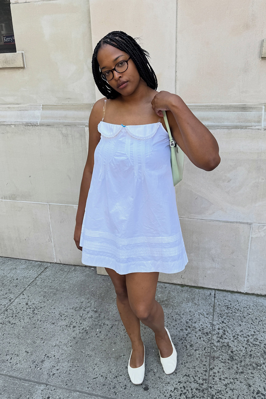a woman wearing a white babydoll dress with flats