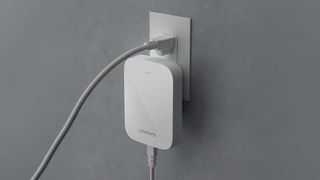 A Linksys RE7350 wi-fi extender plugged into a socket.