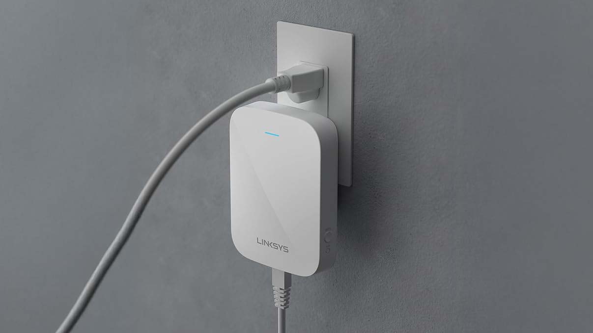 A Linksys RE7350 wi-fi extender plugged into a socket.