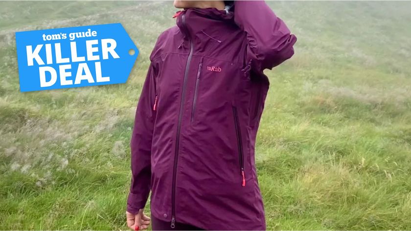 a picture of writer Jessica Downey wearing the Rab Firewall Mountain Waterproof Jacket with a Tom&#039;s Guide Killer Deal label on the top left corner