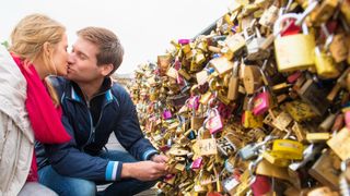 Couple kissing on the famous Love Locker bridge in Paris