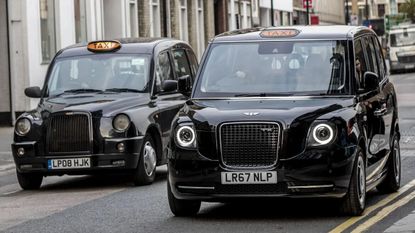 Two London black cabs on the road