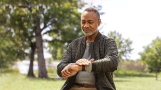 Man checking stress levels using a Fitbit Sense