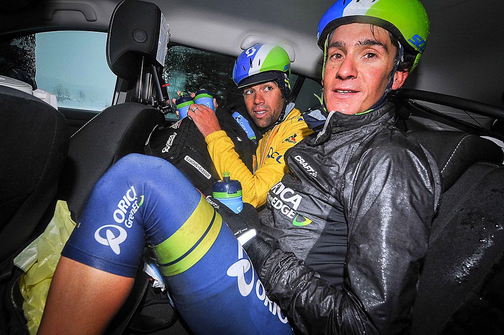 Race leader Michael Matthews and Amets Txurruka take cover in an Orica-Greenedge team car during stage 3 at Paris-Nice.