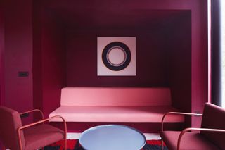 Maggie centre lounge with maroon walls and pink seating