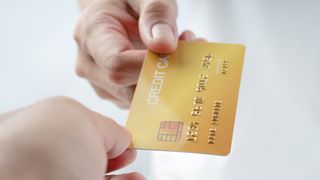 A credit card passed between two hands