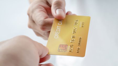 A credit card passed between two hands