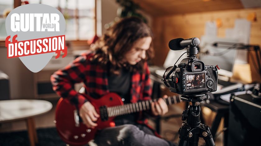 A male guitar player plays electric guitar in front of a rolling camera 