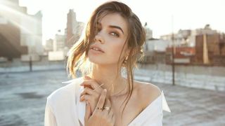 Girl is white on rooftop wearing AUrate jewelry