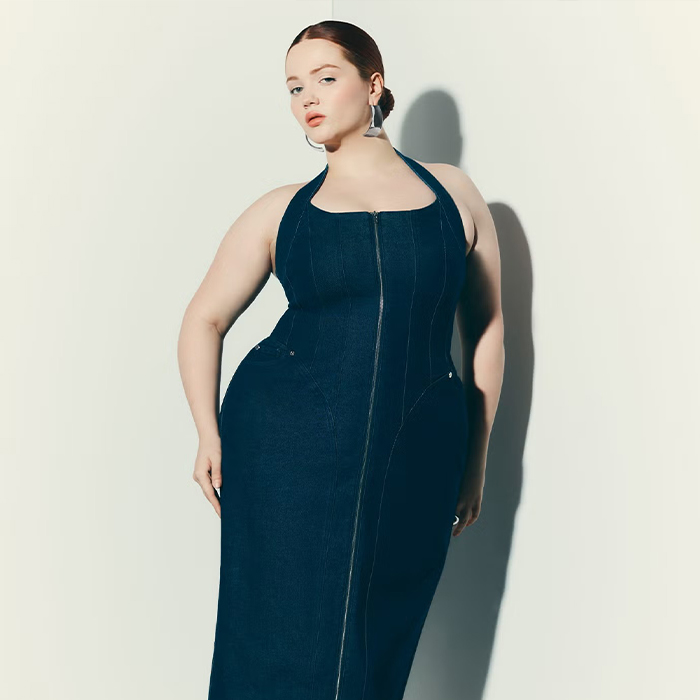 model wears denim corset dress from Eloquii while posing