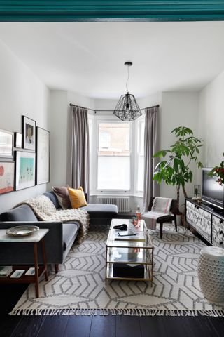 Small living room with berber rug, grey sofa and black and white TV unit