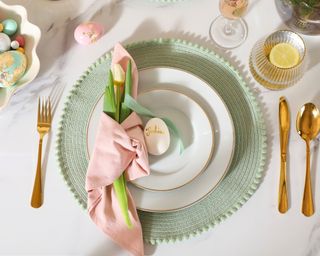 Easter place setting with personalized egg place name, and tulip wrapped in napkin.