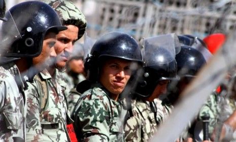 Egyptian soldiers outside Cairo&amp;#039;s defense ministry: To loosen the military council&amp;#039;s grip on Egypt, the U.S. may be forced to revoke financial aid.