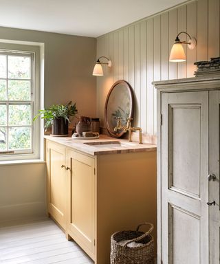 utility room with yellow unit, panelled walls and two wall sconces
