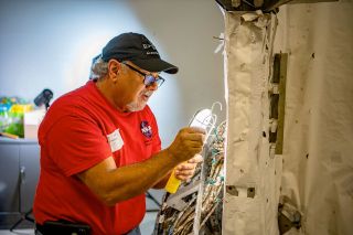 Retired NASA engineer Mike Haddad inspects the Astro cruciform during refurbishment efforts at the U.S. Space & Rocket Center in Huntsville, Alabama.