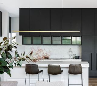 A black and white kitchen with backsplash ending just above the counter