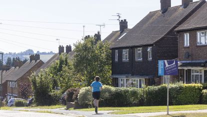 A jogger runs past houses