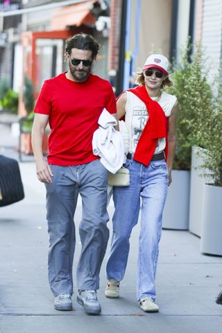 A photo of Gigi Hadid and Bradley Cooper matching in pops of cherry red for a walk around Manhattan.