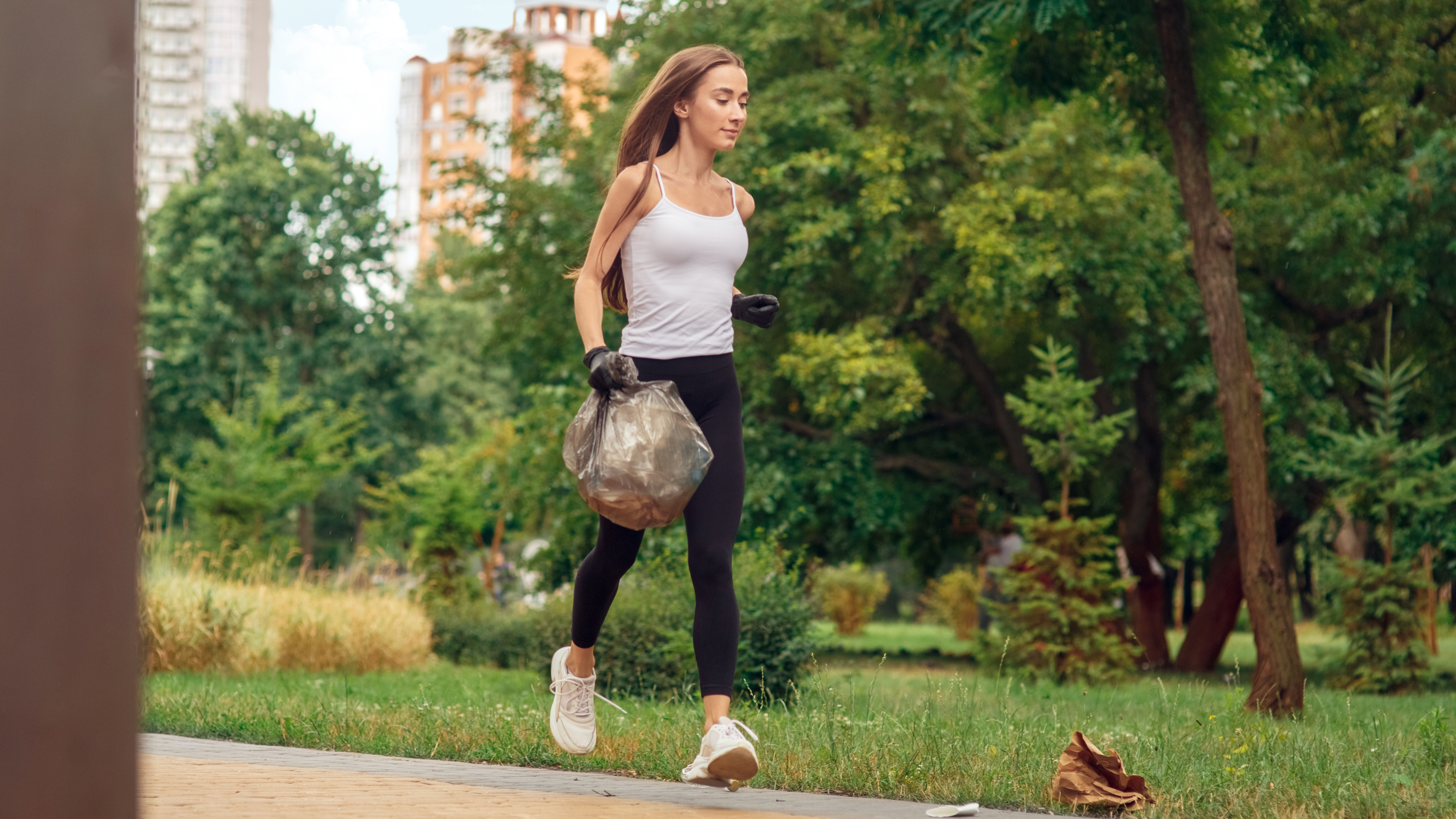 a woman running with a bin bag in one hand