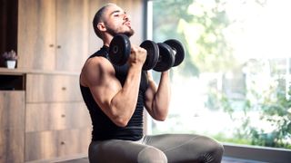 a man performing bicep curls on a bench with a pair of dumbbells