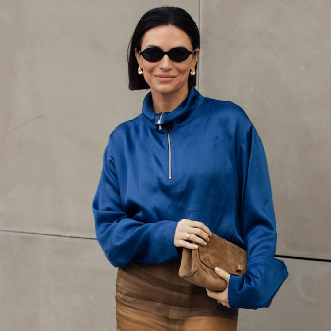 woman wearing a blue jacket and tan skirt. 