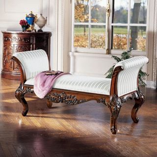 An ornate wooden, upholstered bench from Wayfair