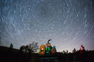 Star trails swirl over three smiling jack-o'-lanterns in this night-sky photo by amateur astronomer Gowrishankar L.