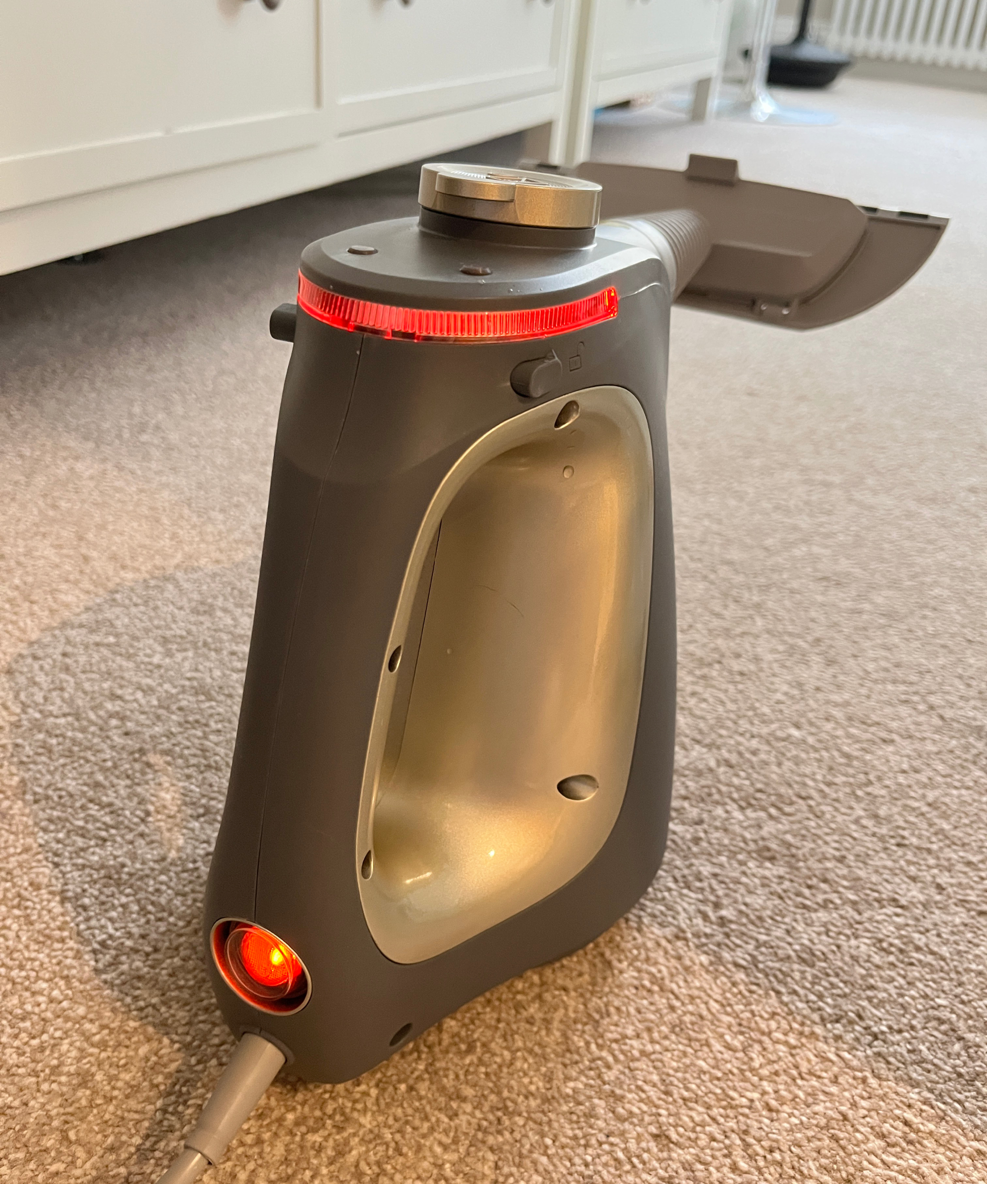 steam cleaner on floor showing red light around top and red on and on off switch