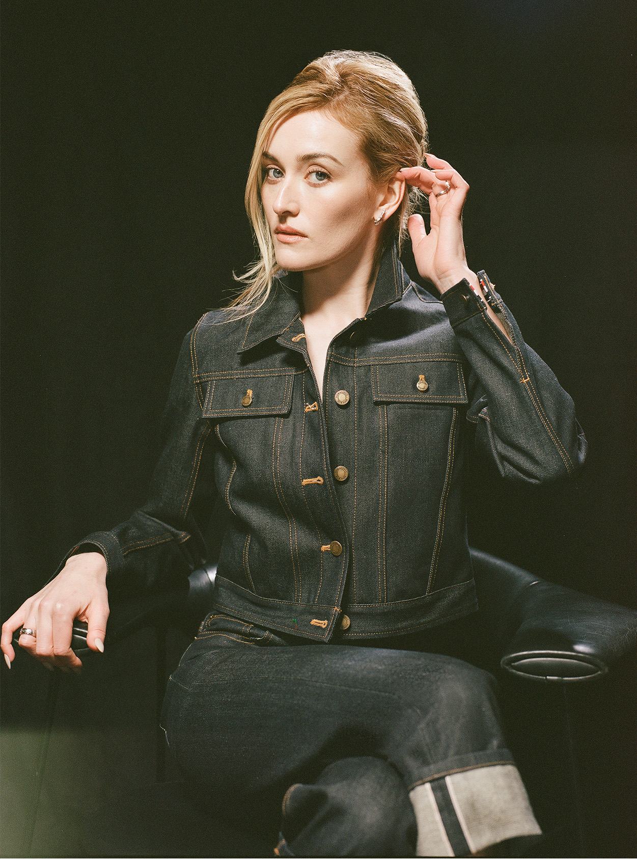 Sarah Pidgeon wearing a denim jacket and jeans and sitting on a chair