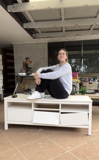 Ebony sitting on top of the broken IKEA HEMNES unit she bought second hand