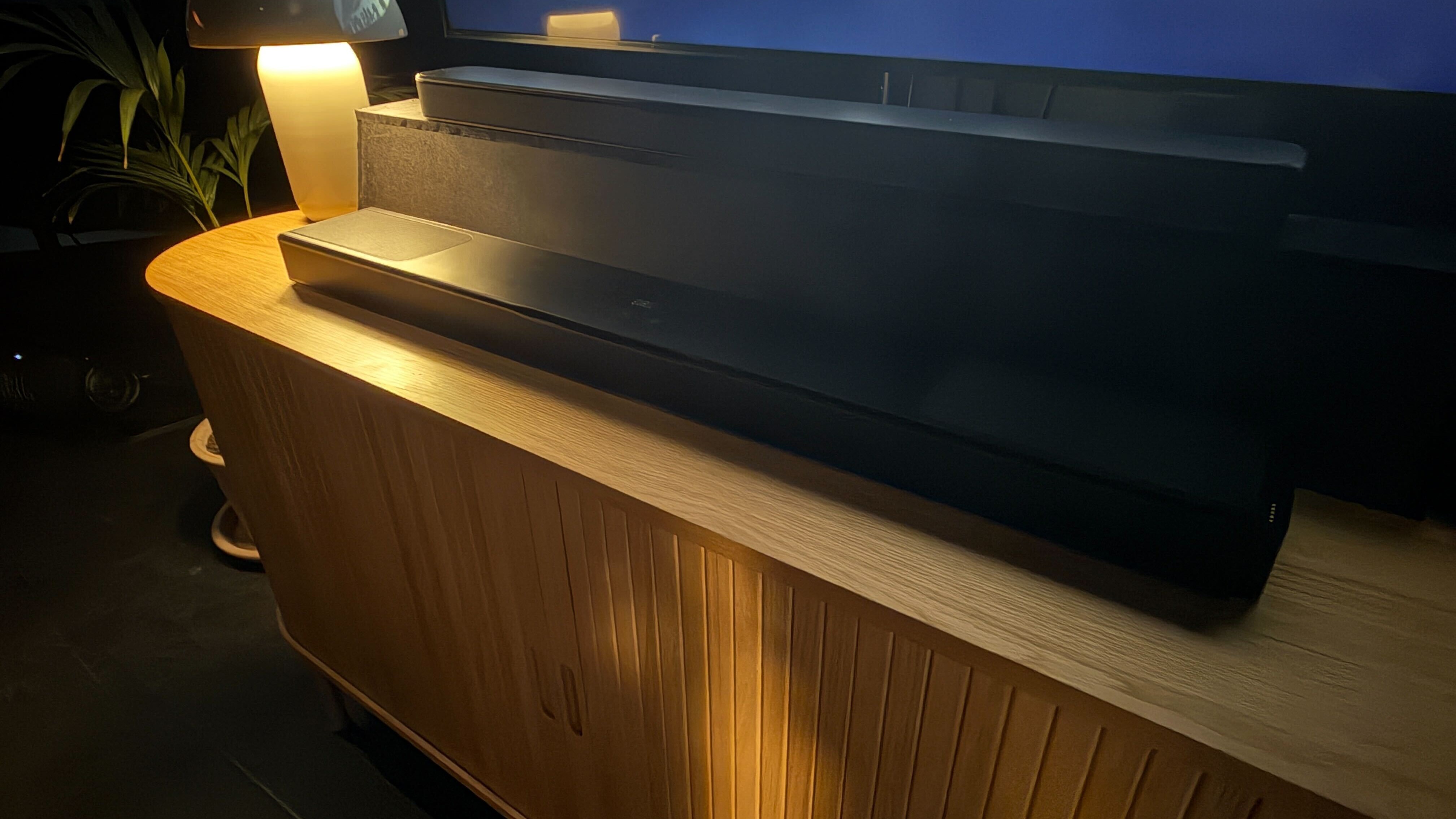 JBL Bar 1300MK2 in a dark room on a wooden table