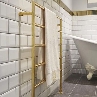 bathroom with white wall and slim gold towel warmer