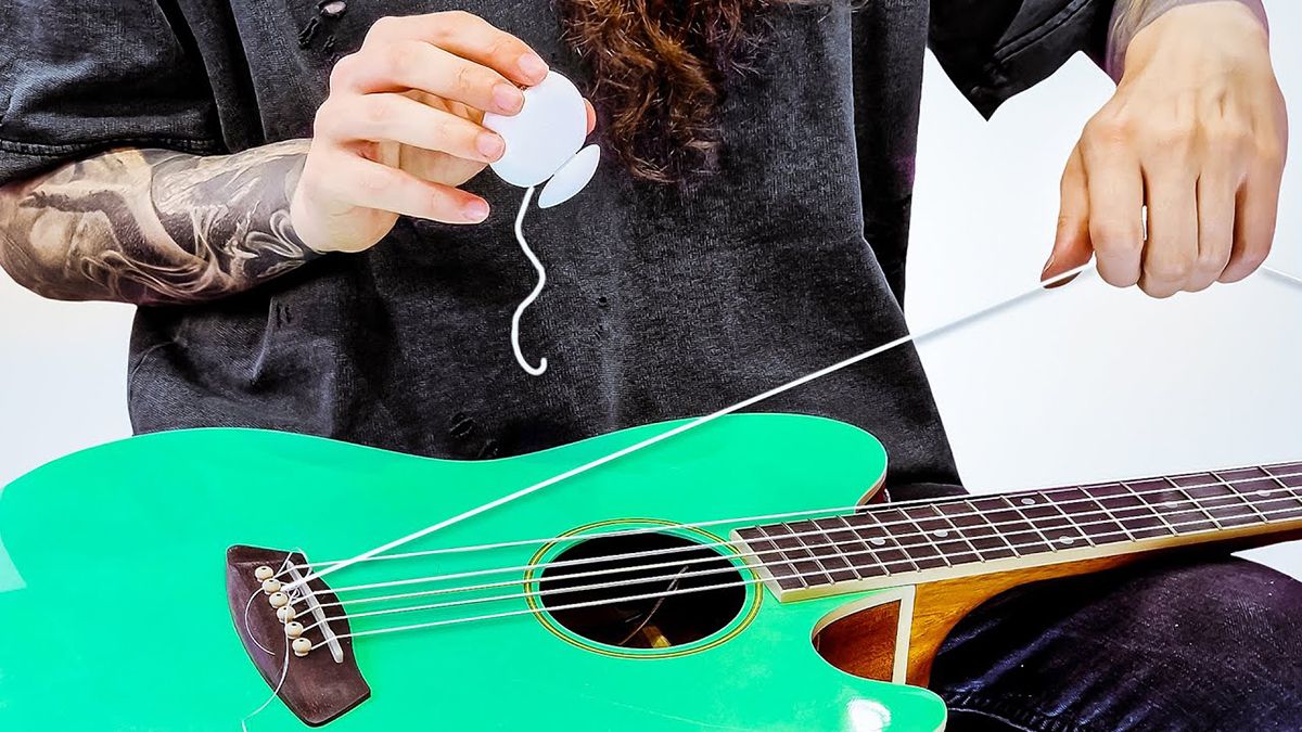 Bernth with a guitar that has dental floss as strings