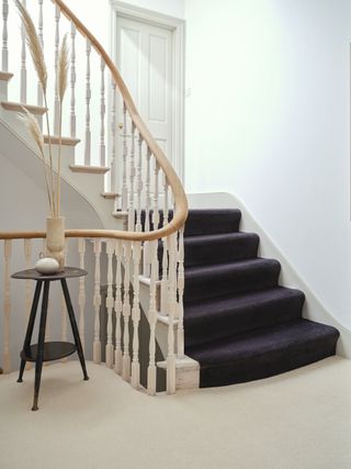 black stair carpet in white renovated hallway