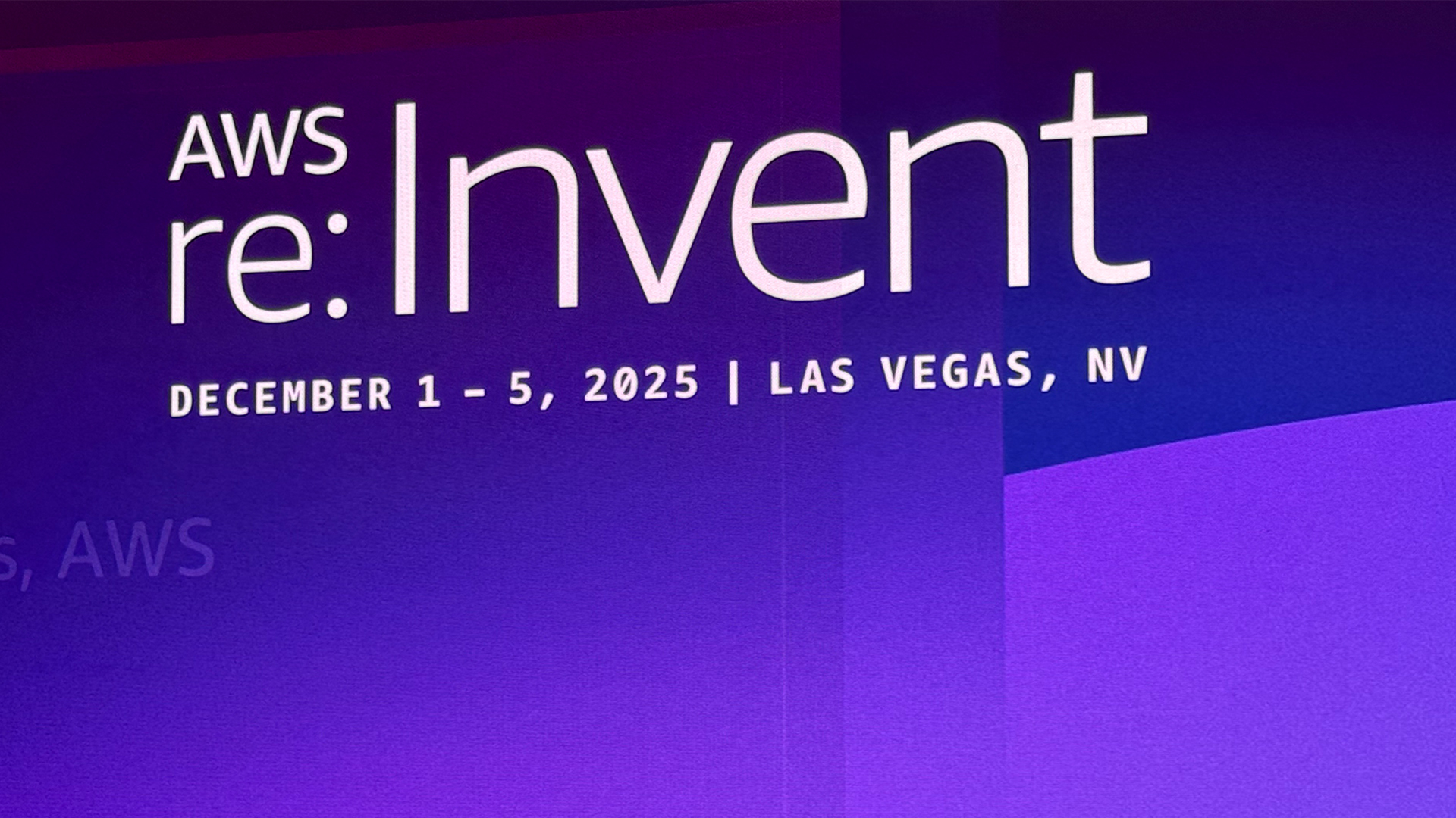 AWS re:Invent 2025 branding pictured on a screen at a press briefing at the annual conference in Las Vegas Nevada. 
