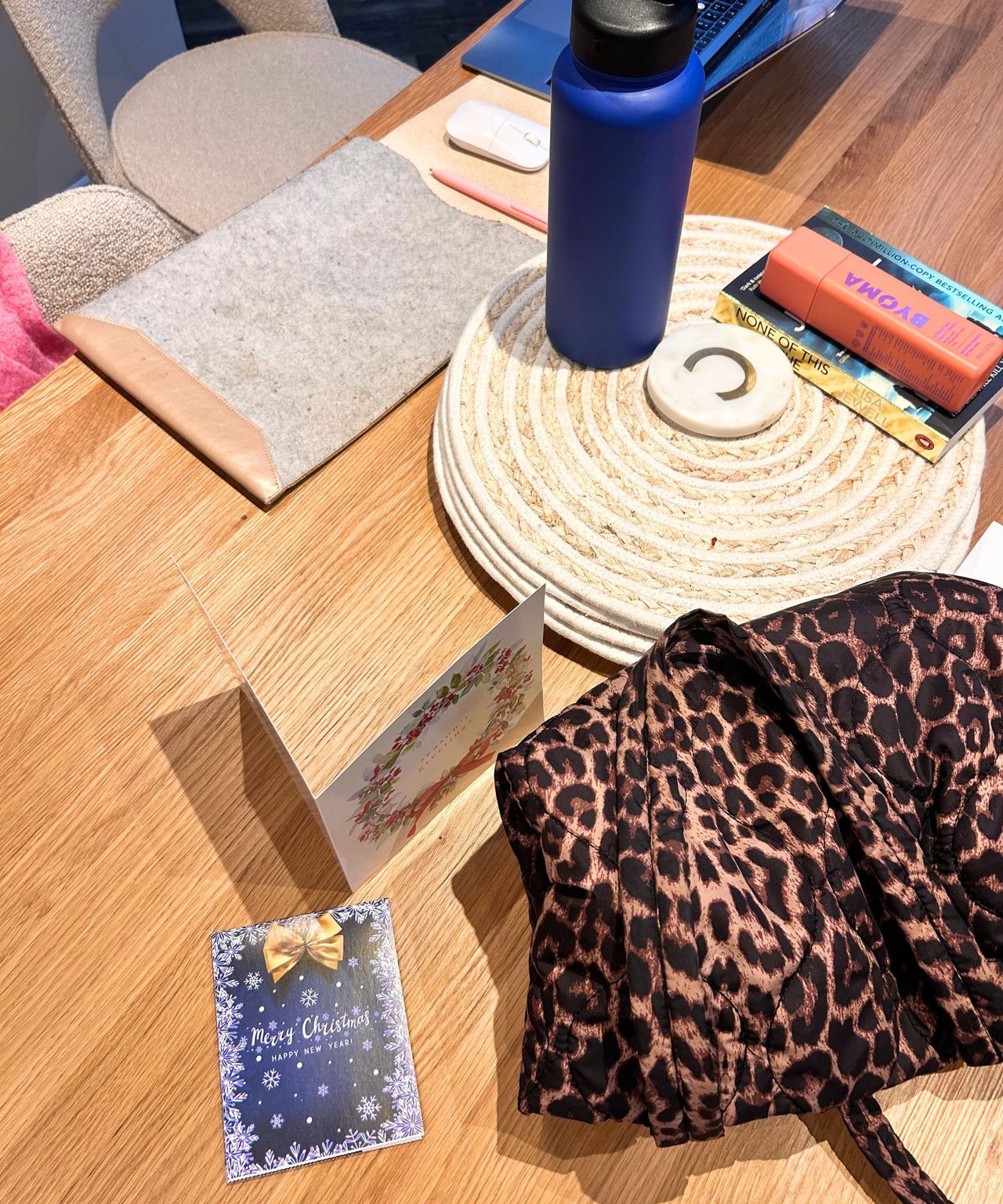 Messy dining room with cards, a bag and a book laid. ontop