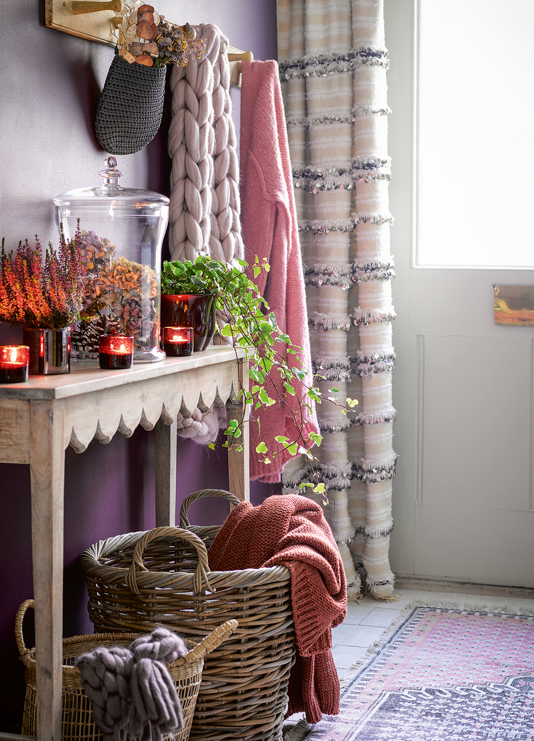 hallway with cosy layers and scalloped console table with hurricane lantern and burning candles