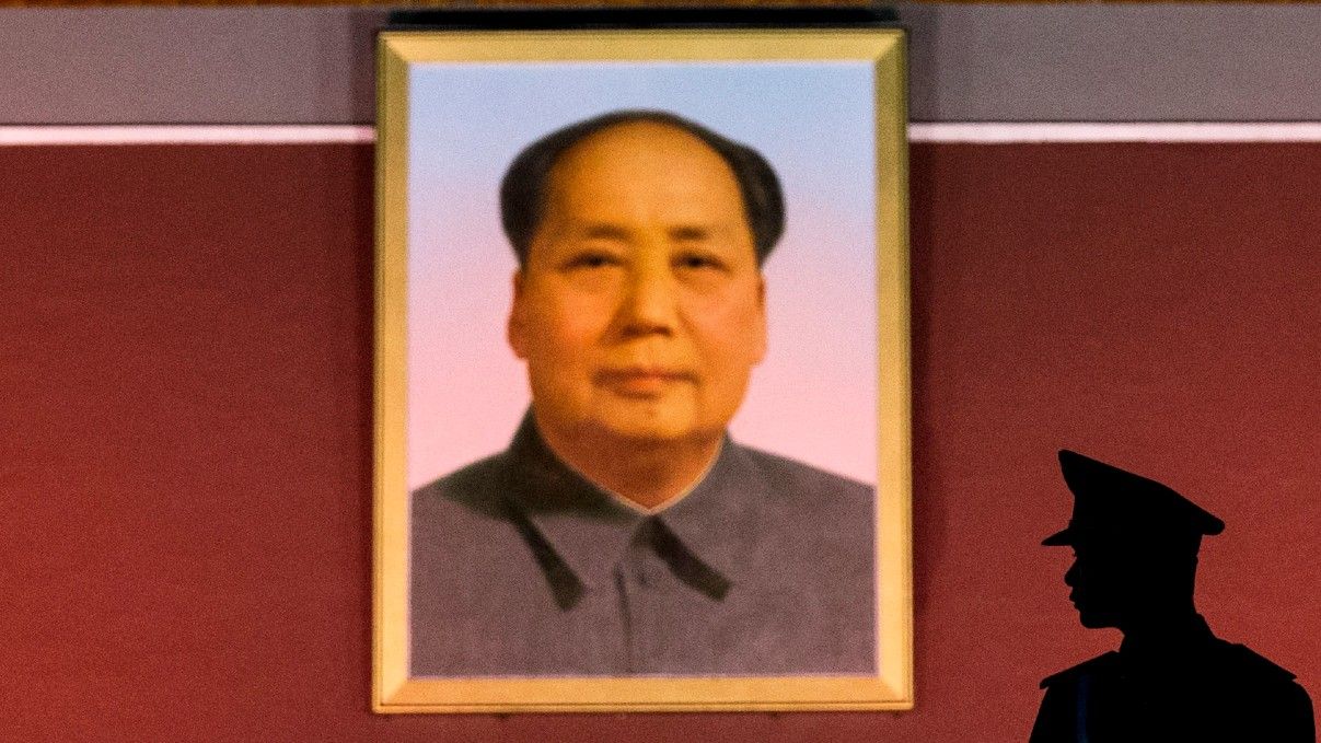 The silhouette of a Chinese soldier in front of a picture of Mao Zedong, Tiananmen Square, Beijing