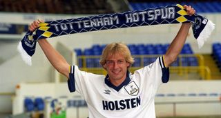 Jurgen Klinsmann holds a Tottenham scarf after signing for Spurs in 1994.
